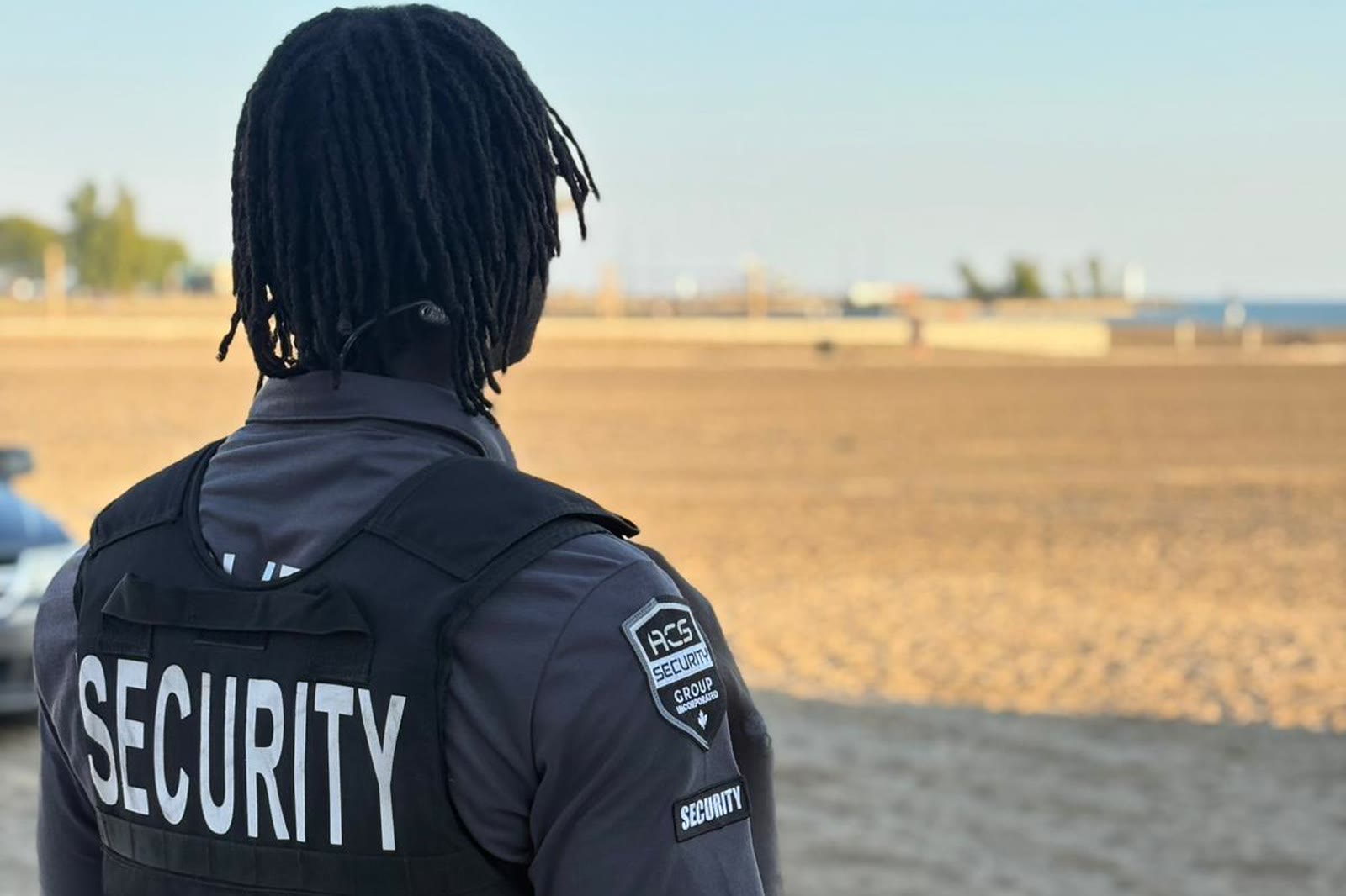 An ACS officer on foot patrol at a public waterfront in daylight