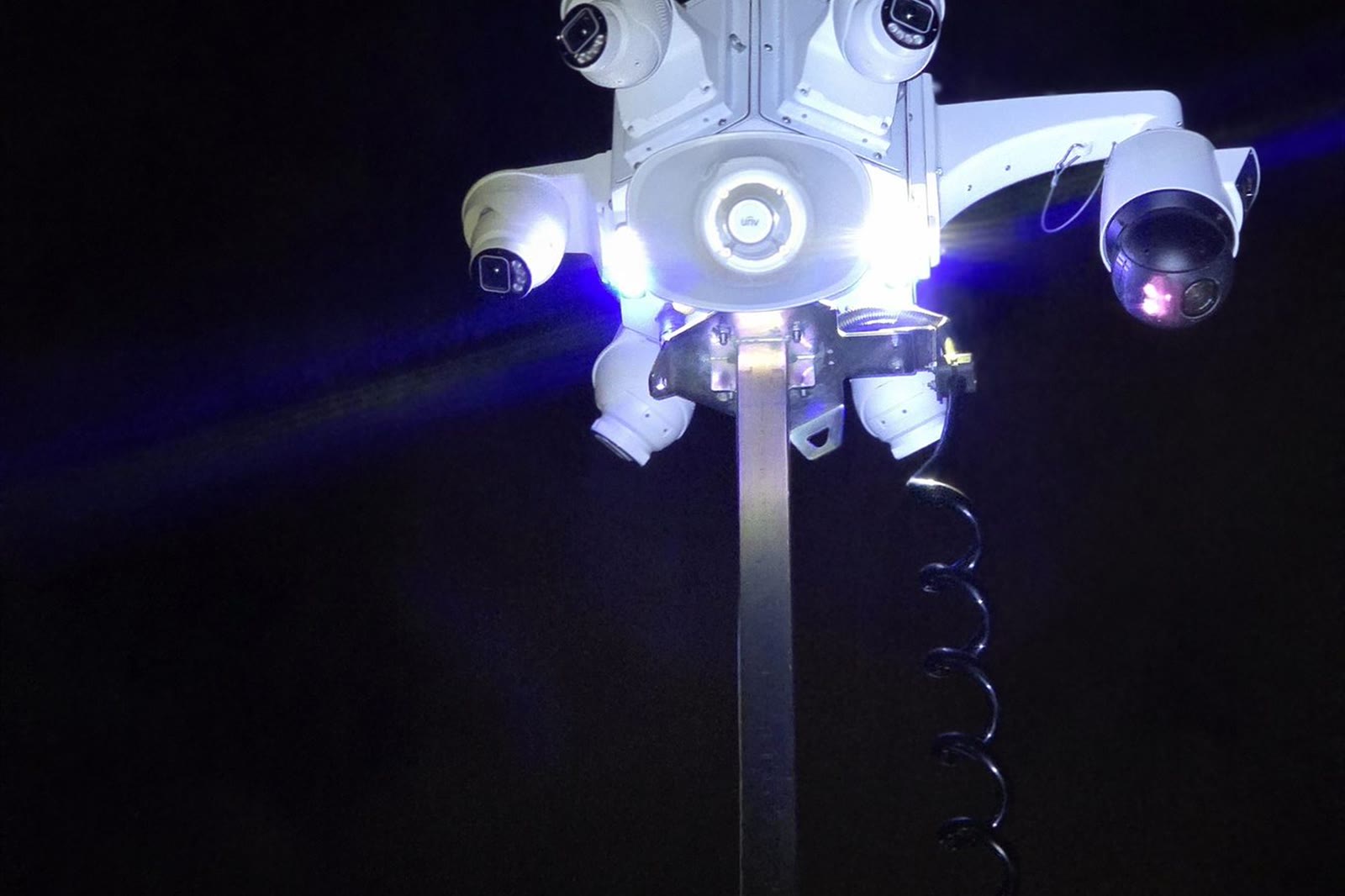 An ACS multi-camera head lit at night on top of a mast