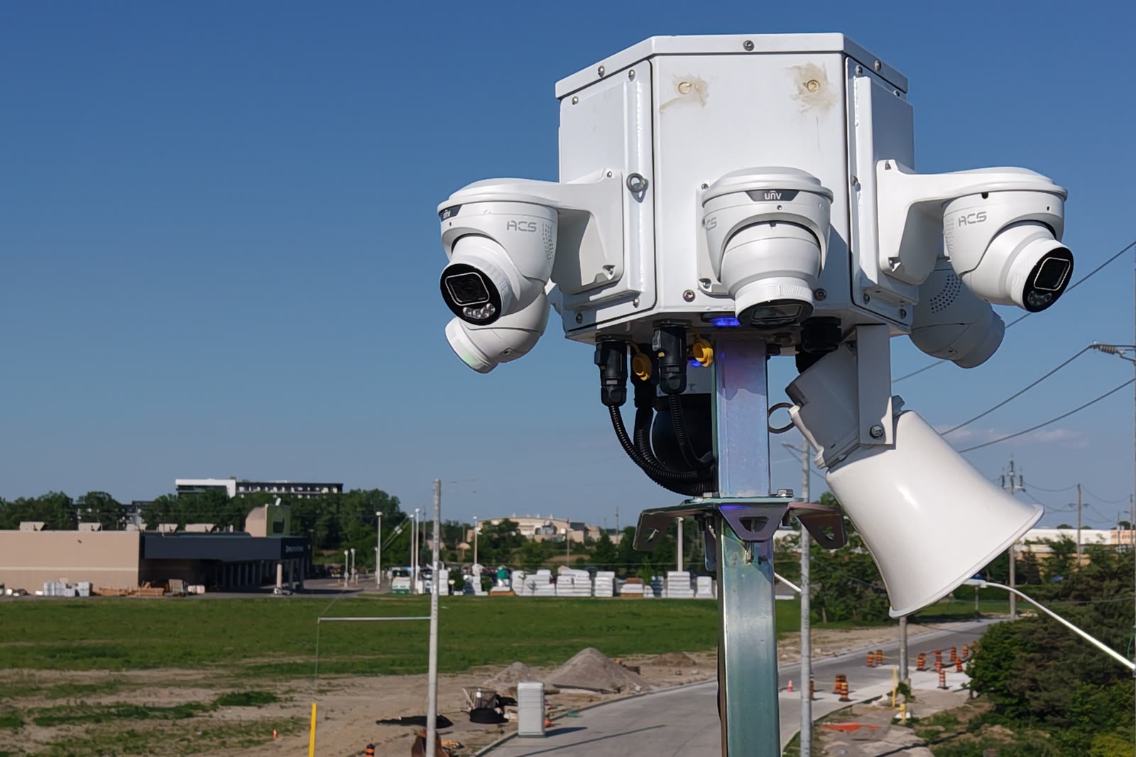 An ACS camera cluster on a raised mast above a working yard