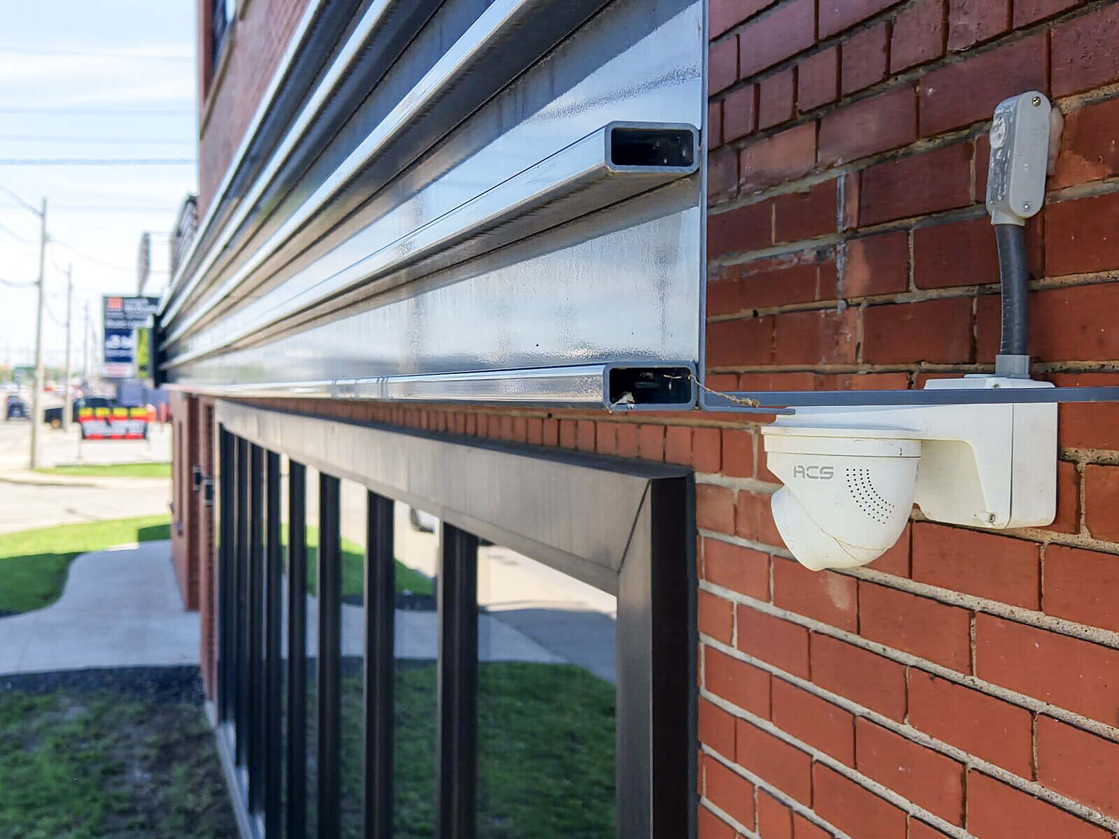 ACS camera mounted on a commercial plaza storefront overlooking the sidewalk and street