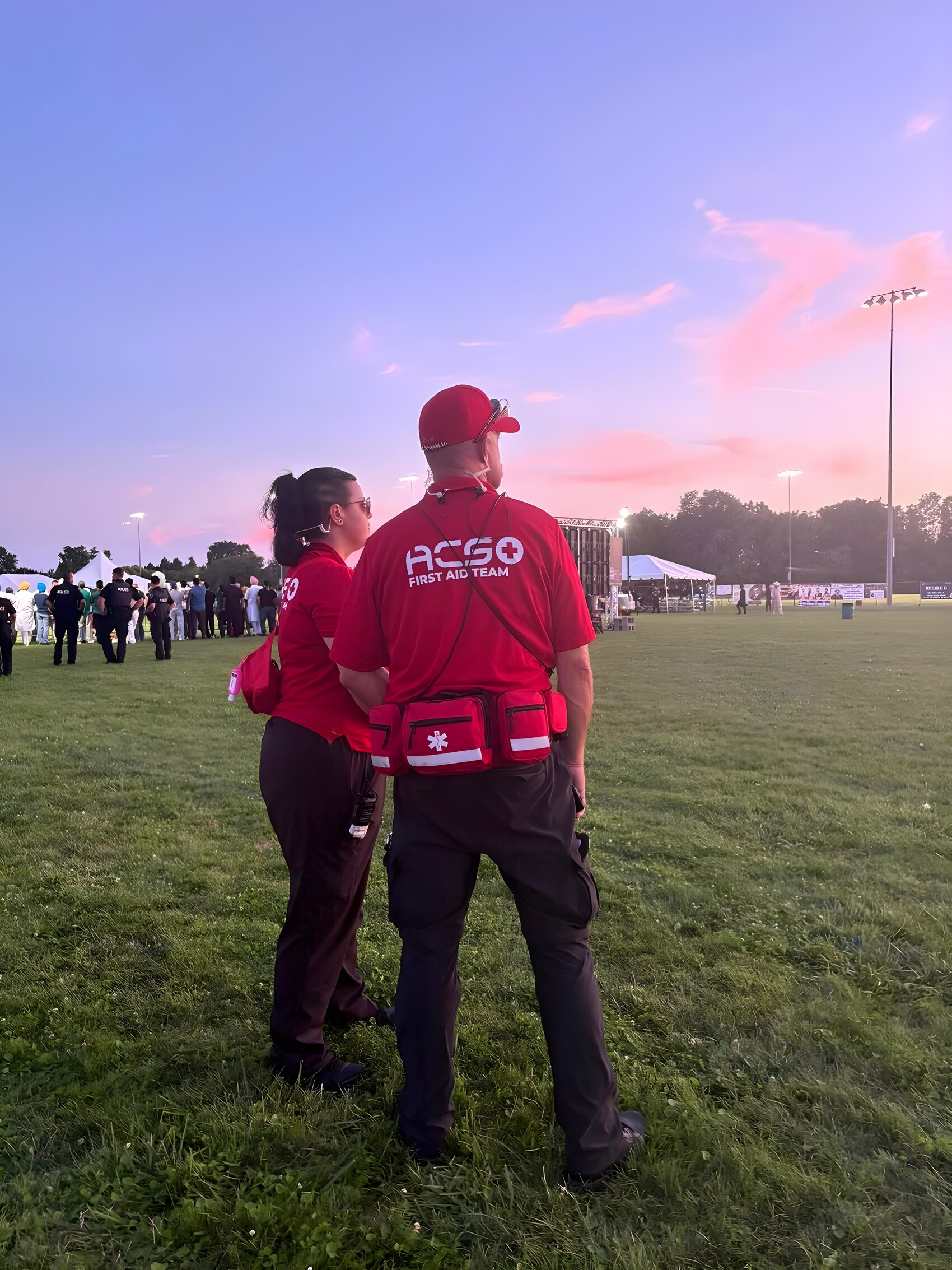 ACS First Aid Team members in red shirts at an outdoor evening event