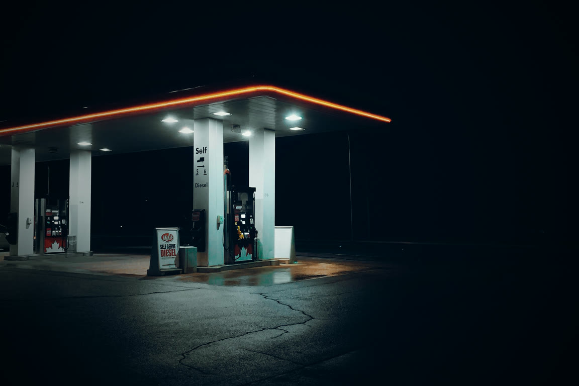 A closed fuel forecourt lit through the night