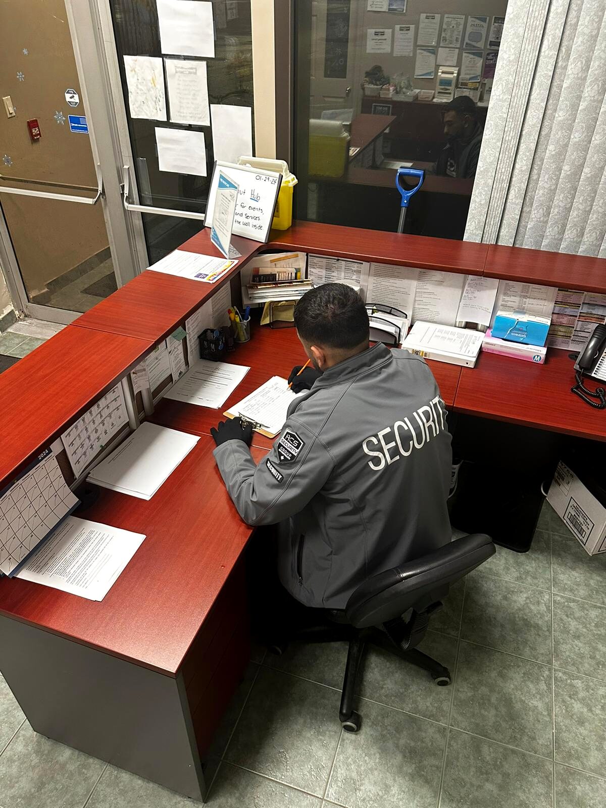 ACS guard completing reports at a site security desk