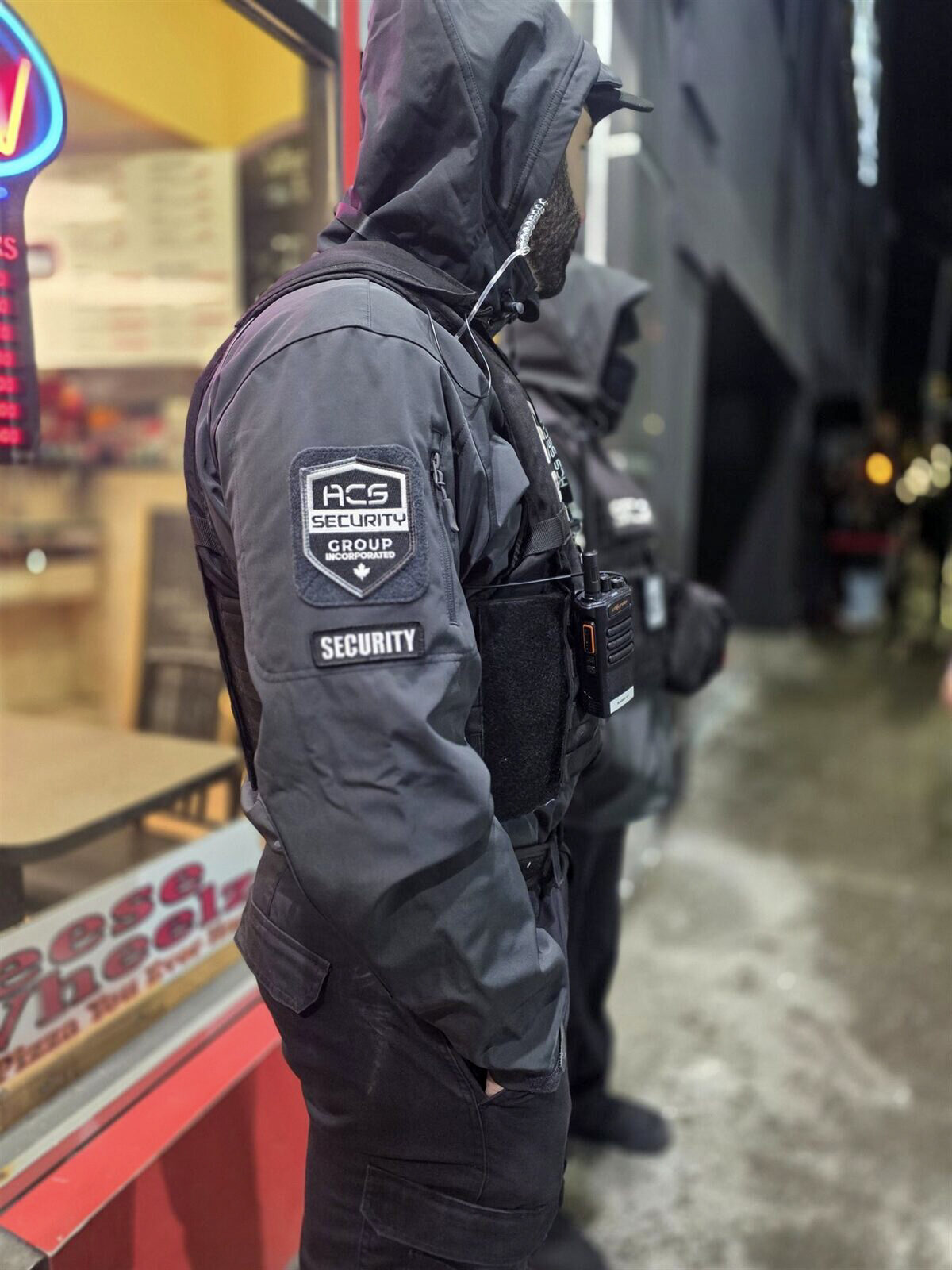 ACS security guards on post outside a Windsor restaurant storefront at night