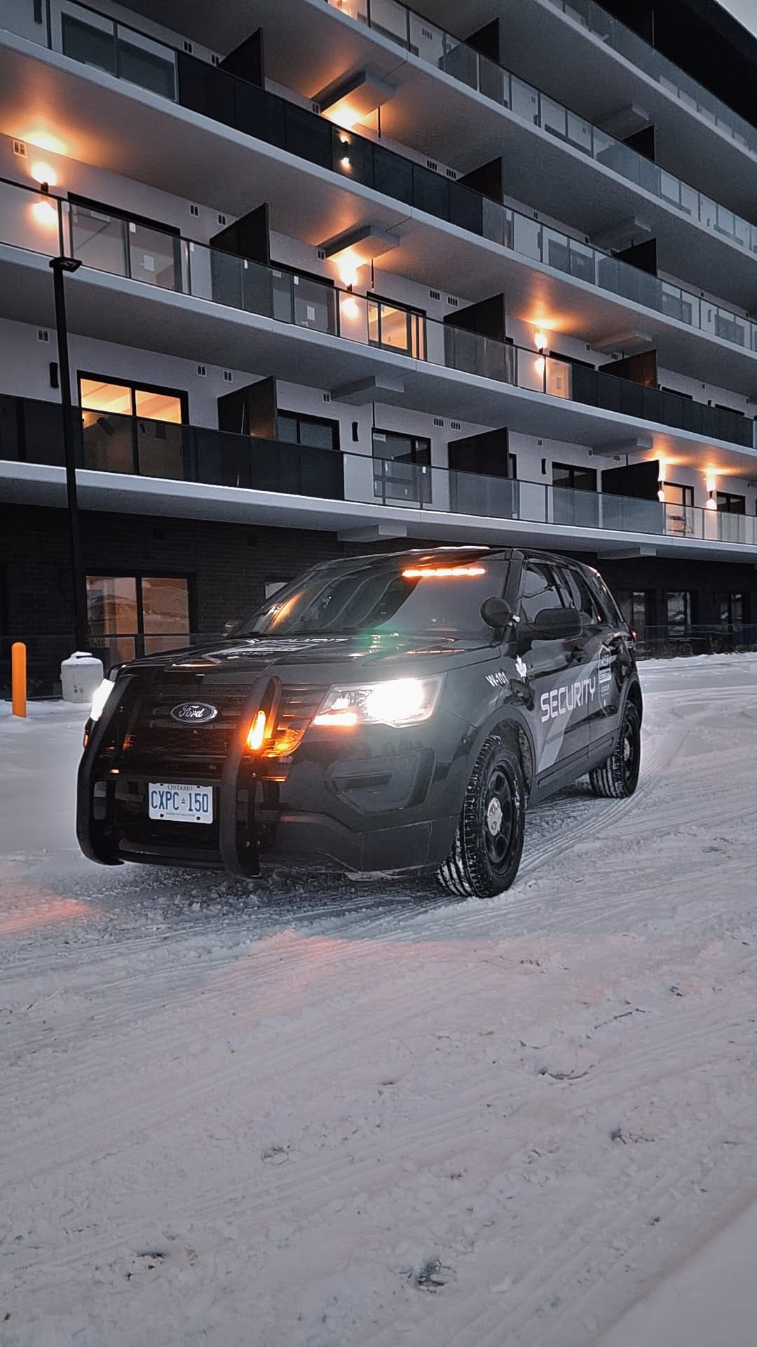 ACS mobile patrol unit W-101, a marked black Ford Explorer, parked at night in the snow outside a lit residential building