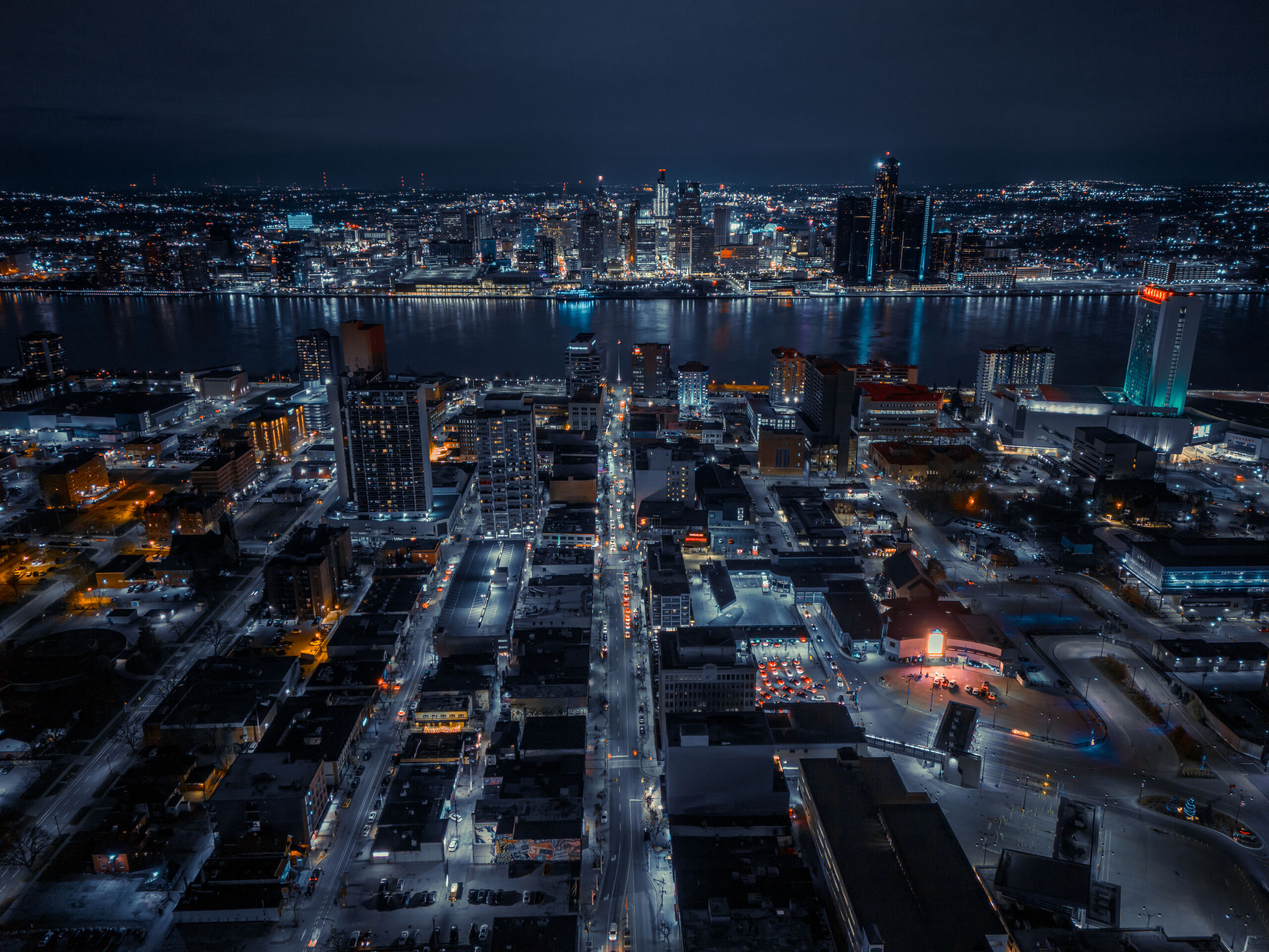Aerial night view of downtown Windsor with the Detroit River and the Detroit skyline beyond