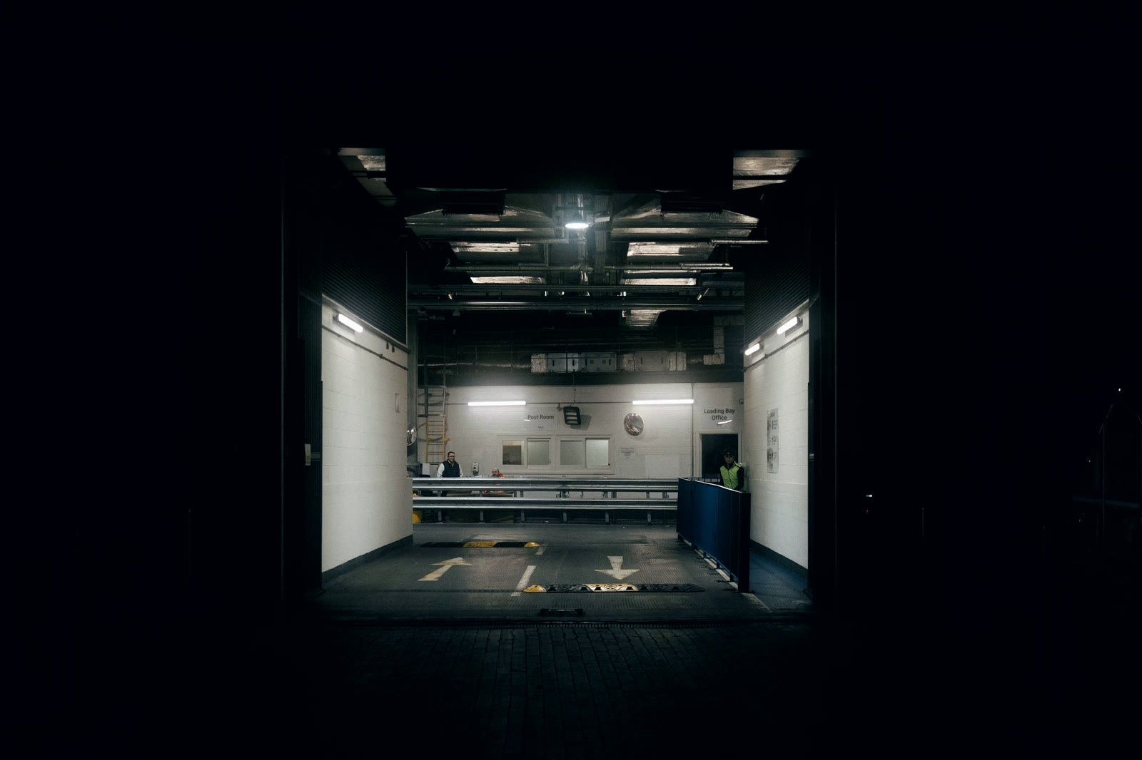 A lit loading opening in an otherwise dark building face