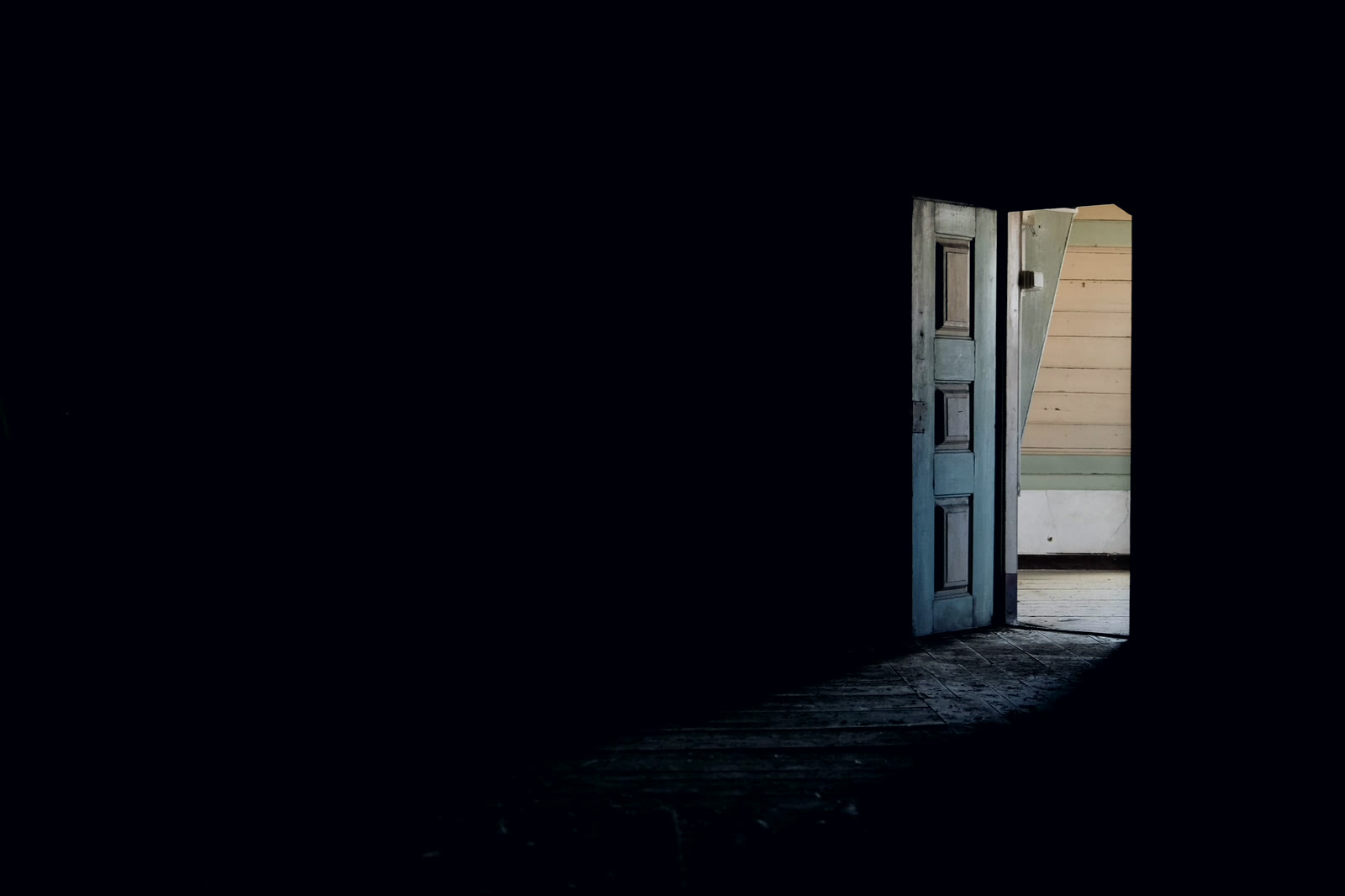 An open door with light spilling into a dark room