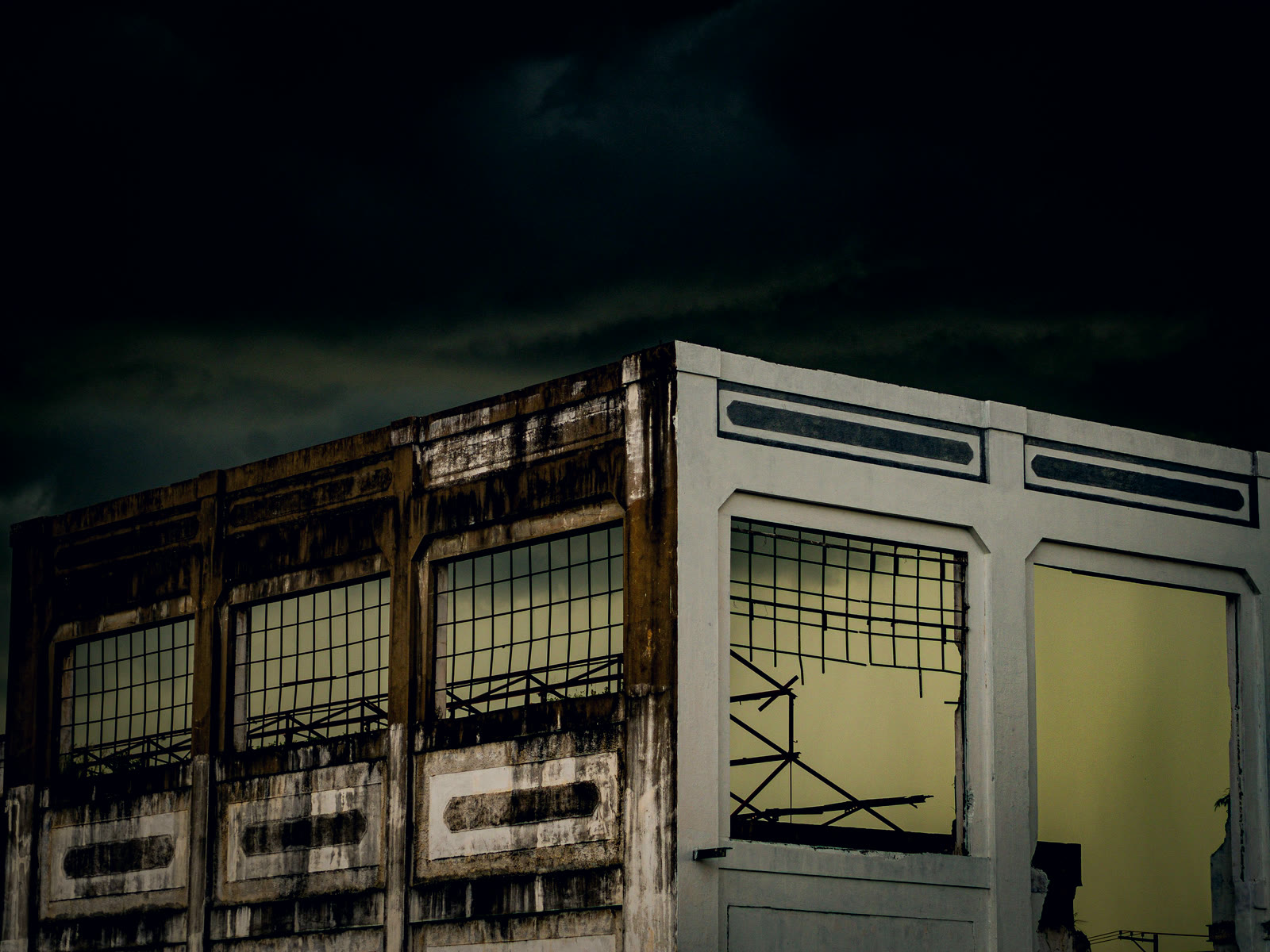 A boarded-up building standing empty under a heavy dusk sky