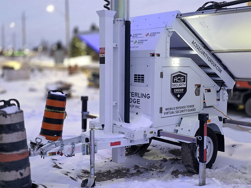 ACS mobile defense tower trailer in snow beside orange traffic barrels