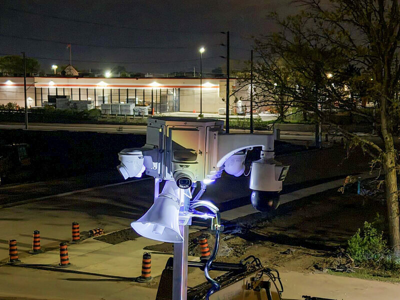 ACS camera tower lit at night over a parking lot lined with traffic cones
