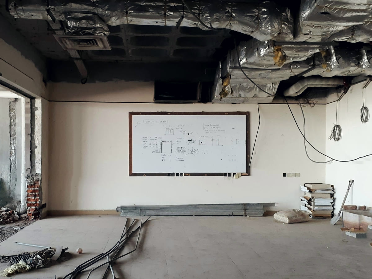 An empty commercial room at fit-out stage with the ceiling open and services run
