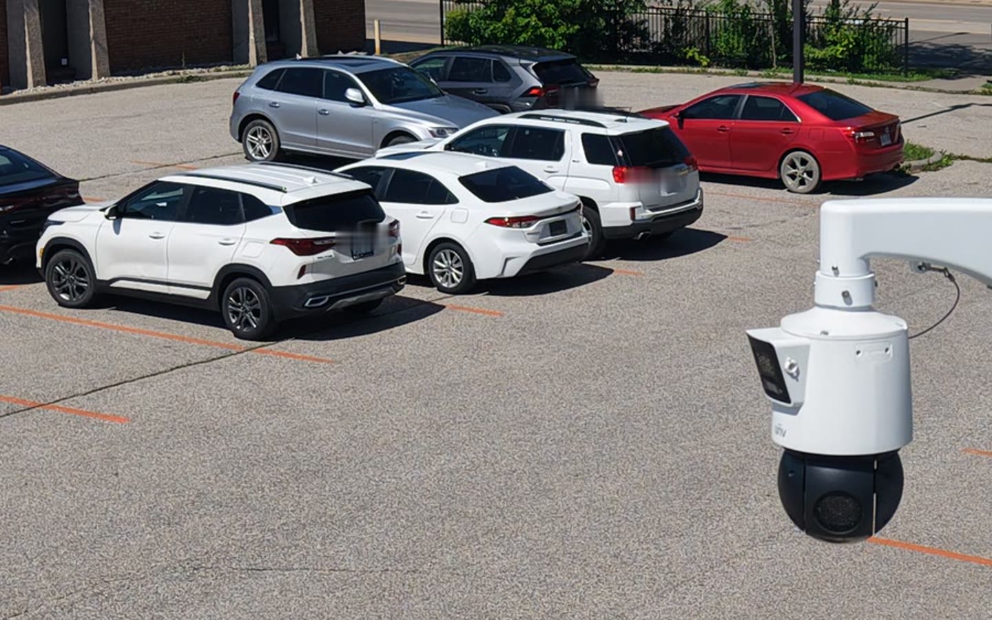 An ACS pan-tilt-zoom camera overlooking rows of parked vehicles on a dealership lot