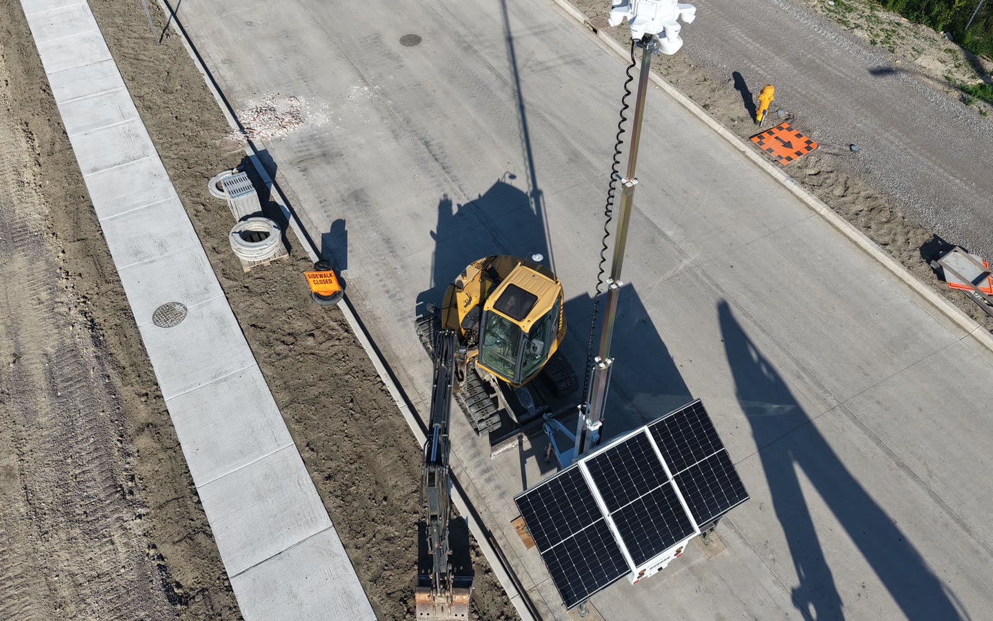 An aerial view of an ACS tower on a working site, plant and road below it