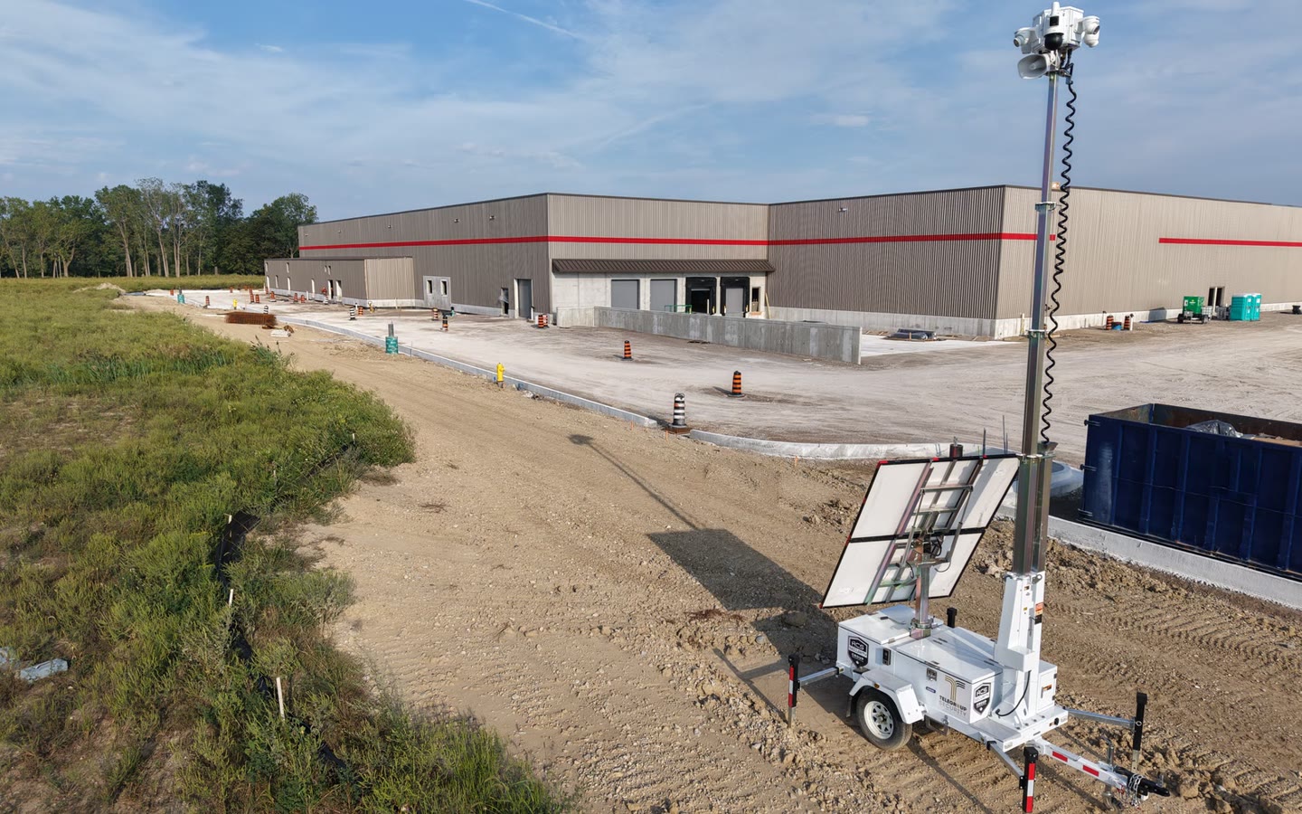 An ACS mobile tower on the site of a retail unit under construction, loading doors and graded ground behind it